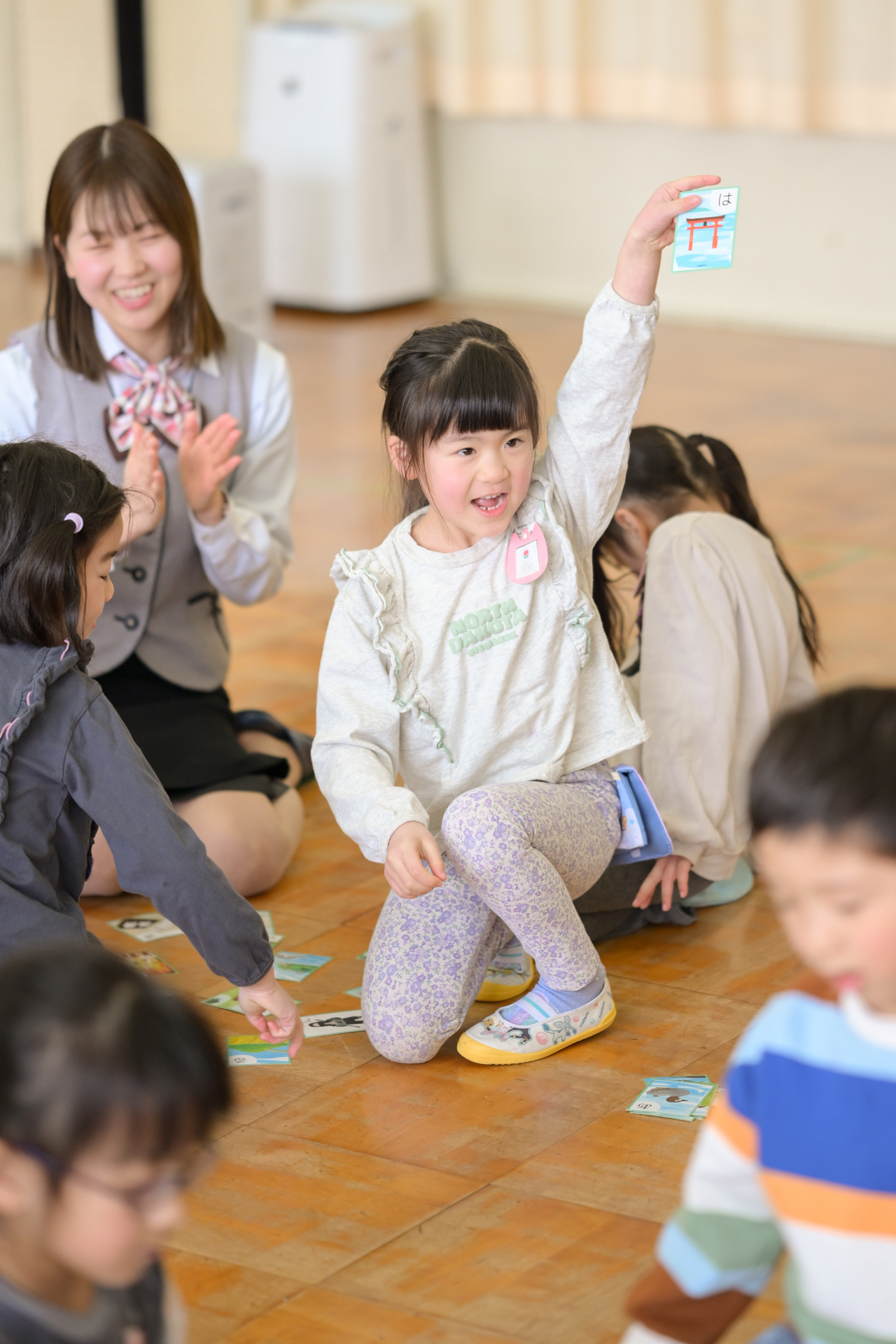 子どもがカルタをとってよろこんでいる様子