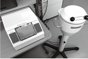 机の上の機械と、キャスター付きで床に置かれた放射性物質測定器の写真