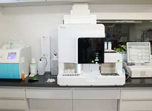 機械の左右に検体を置く台があり中央に黒いカバーがついている全自動尿分析装置の写真