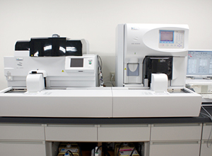 2台の血液分析装置が並べられている横にモニターが置かれている写真
