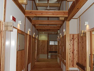 天井の梁が見え、床、柱、壁などに木材が使用されている朽木診療所内の写真