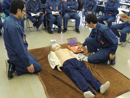 茶色の毛布の上にマネキンを置き2名の消防団員がAEDを使った訓練を行っている上級救命講習の様子の写真