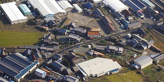 周囲に民家や工場などがひしめき合っている紺藤織物の会社を上空から撮影した写真