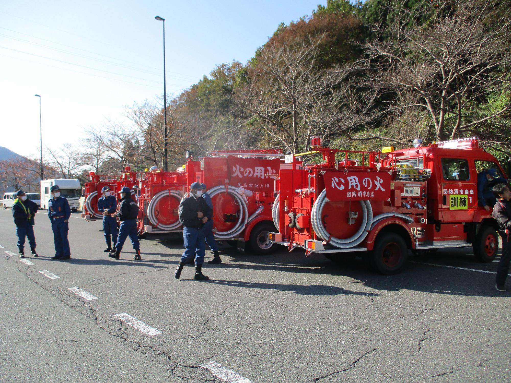 5台の消防車が停車している周りに消防団員が集まっている写真