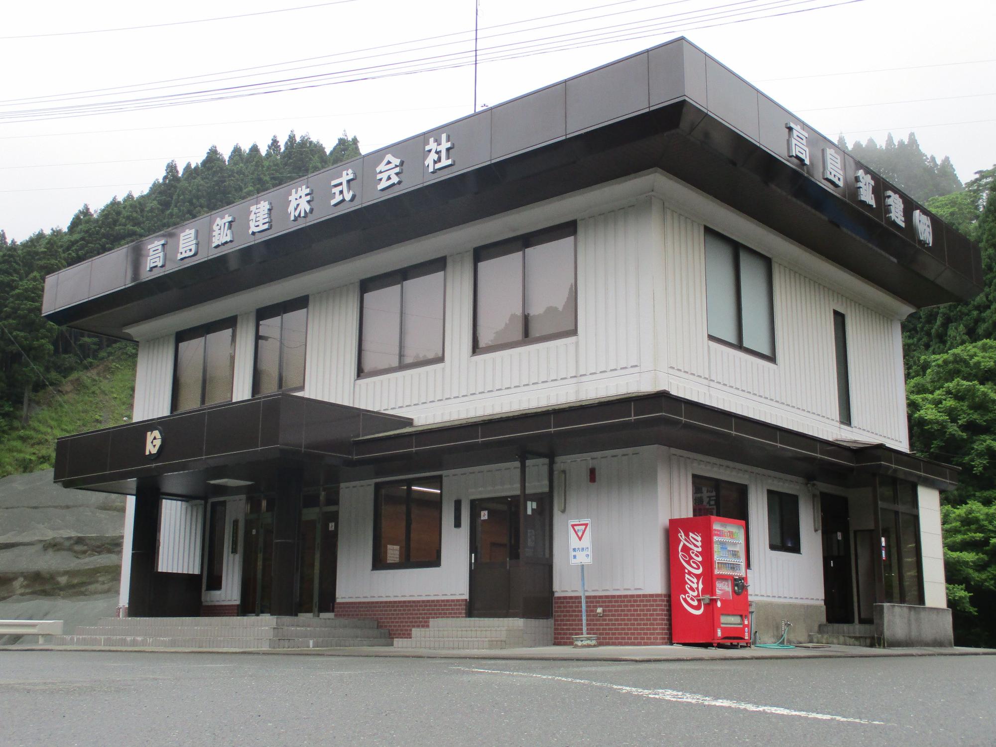 屋根に大きな文字で高島鉱建株式会社と書かれた2階建ての建物外観の写真