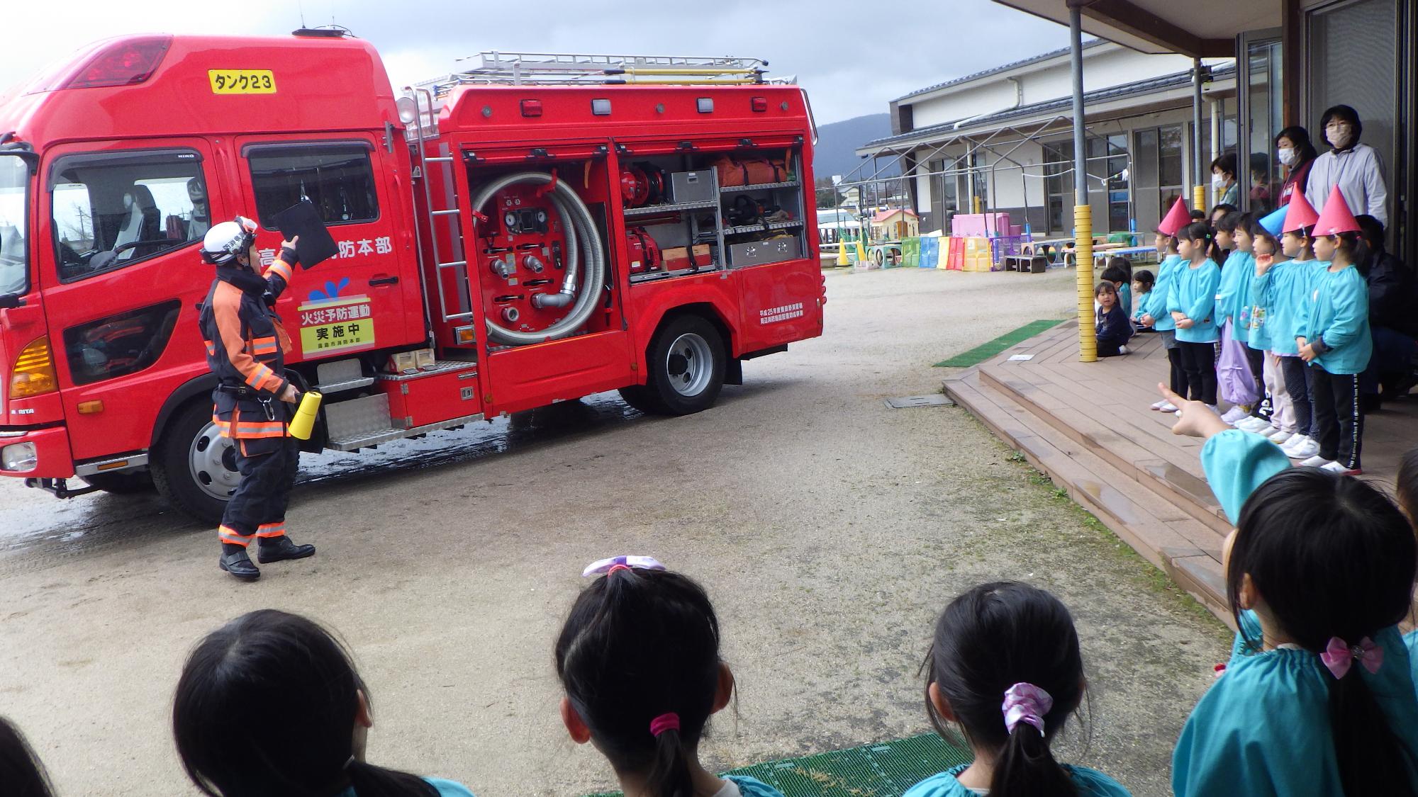 訓練後に消防車の説明を聞く園児の様子
