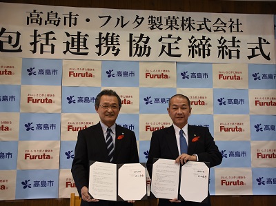 包括連携協定締結式の会場で協定書を持った福井市長と古田社長の写真