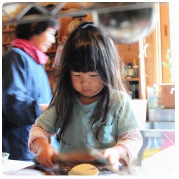 包丁で野菜を切っている小さな女の子の写真