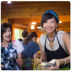 野菜を手に持ち、笑顔でこちらを向く中川さんと女性の写真