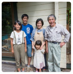 馬込さん夫婦と2人の娘さんと堀田さんがカメラに向かって笑顔を向けている写真