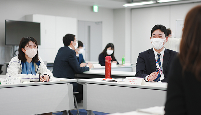 笑顔で先輩職員の話を聴く男女の若手職員