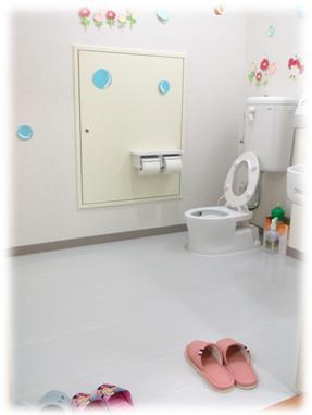 入口に子供用と大人用のスリッパが並べられた洋式トイレの写真