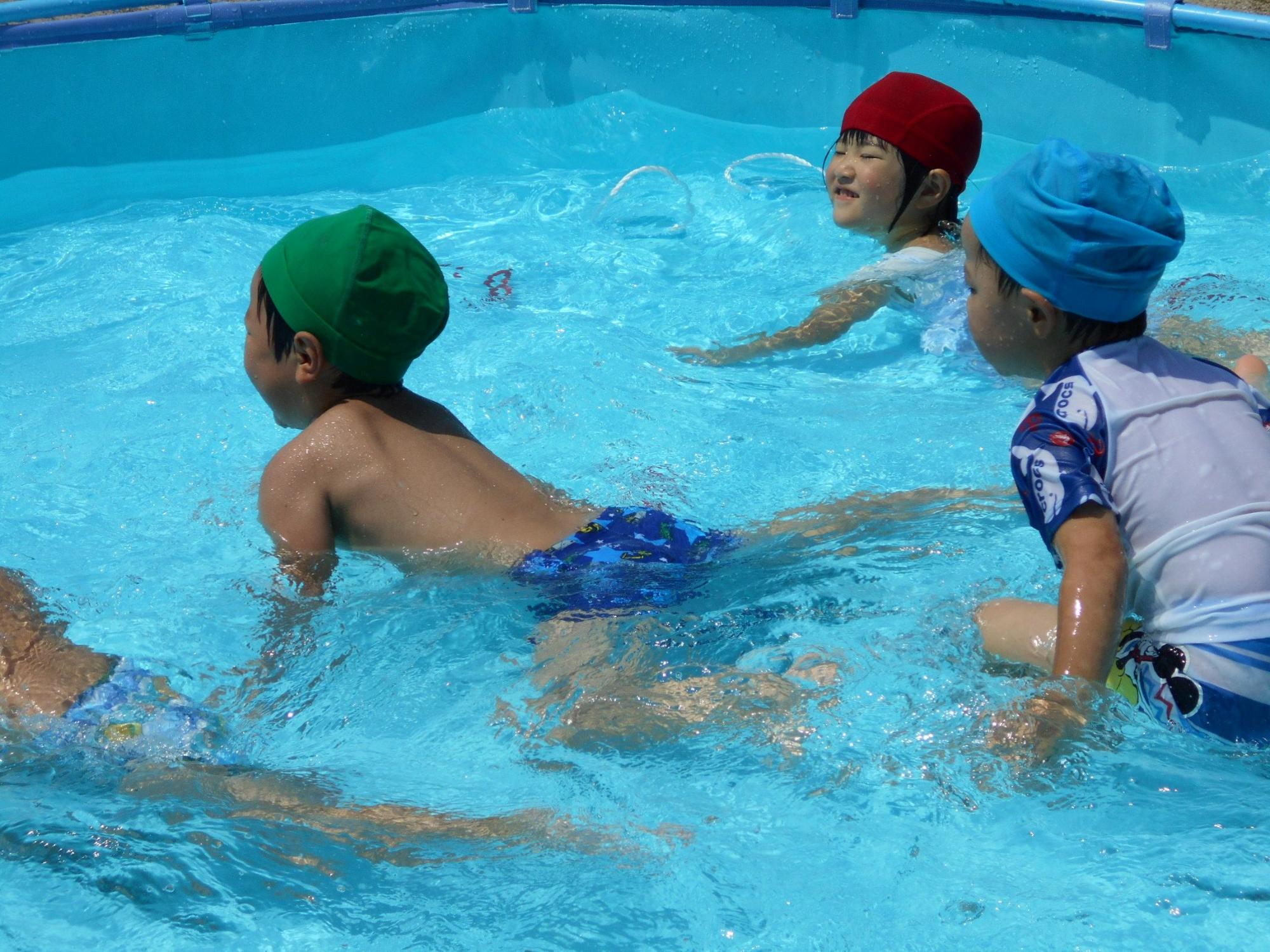 水着を着た子供達がプールで遊んでいる写真