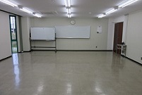 部屋の奥の壁に備え付けのホワイトボードとキャスター付きのホワイトボードが置いてある会議室2-Aの写真