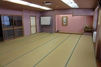 左側にガラスの引き戸があり、淡いピンク色の壁に額縁に飾られた絵や、盆栽のようなものが飾られている和室の会議室3－Bの写真