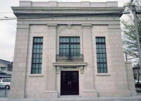 鉄筋コンクリート造の2階建てで中央に入口の扉と3つの大きな窓がある今津ヴォーリズ資料館の外観写真