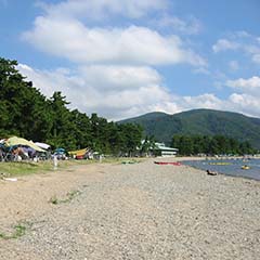 左側に松林、右側に琵琶湖が見える砂浜の写真