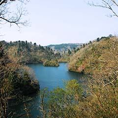 周囲を自然豊かな小高い丘に囲まれた淡海湖の写真