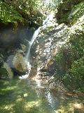 苔のついた岩の隙間から細く水が流れる七遍返し（しちへんがえし）淵の写真