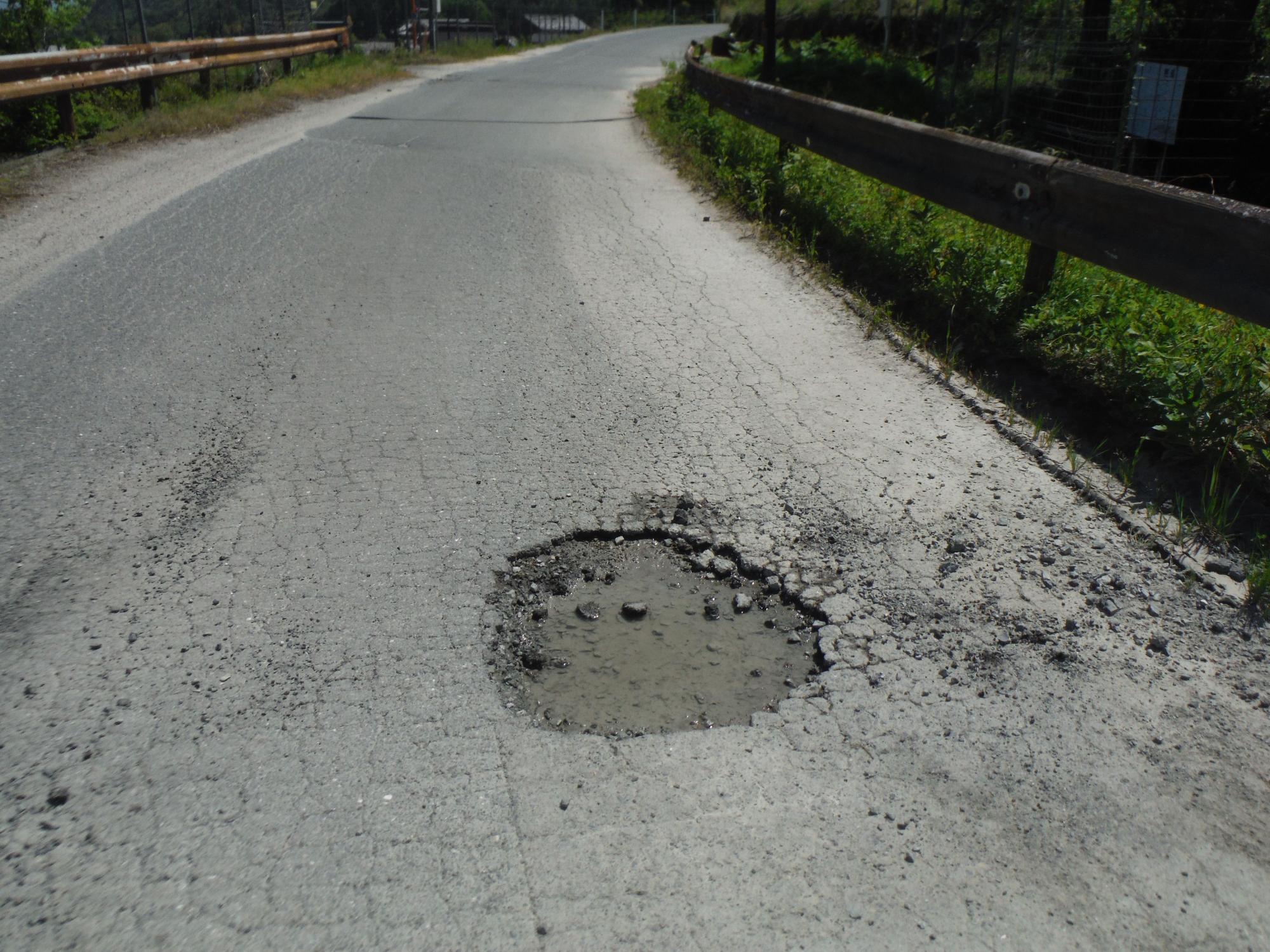道路に1センチ程の深さの丸く大きな穴が開いている写真