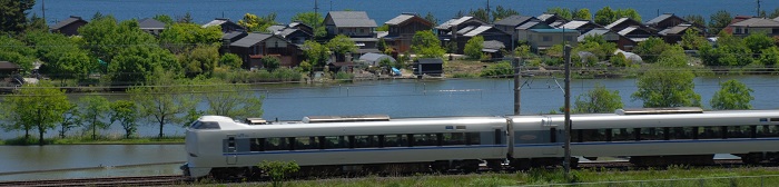 電車が川辺を走っている湖西線の写真