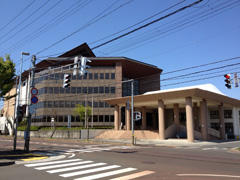 道路側がガラス張りになっている4階建ての高島市民会館の建物外観の写真