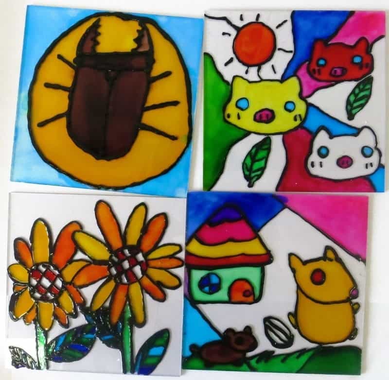 教室に参加した子ども達が描いたカブトムシや花、3匹の猫の顔と太陽、丸窓の家の前を歩いている2匹のハムスターのイラスト