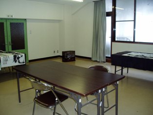 長机が設置してあり、向かい合わせにパイプ椅子が置かれた2階研修室の写真
