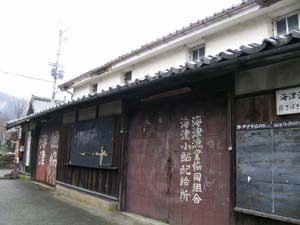 1階部分の壁板が劣化して古くなった2階建て海津漁業協同組合旧倉庫の写真