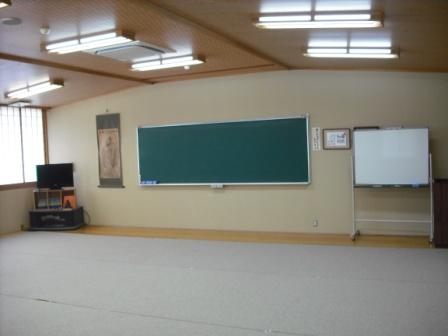 前方に黒板が設置され、右側に白板、左側にテレビが置かれている講義室の写真
