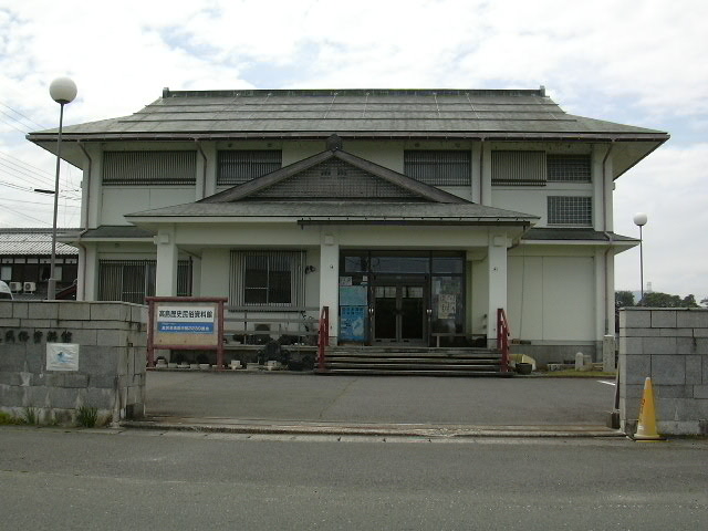 白い外壁で2階建て、入り口に看板がたっている高島歴史民俗資料館の外観写真