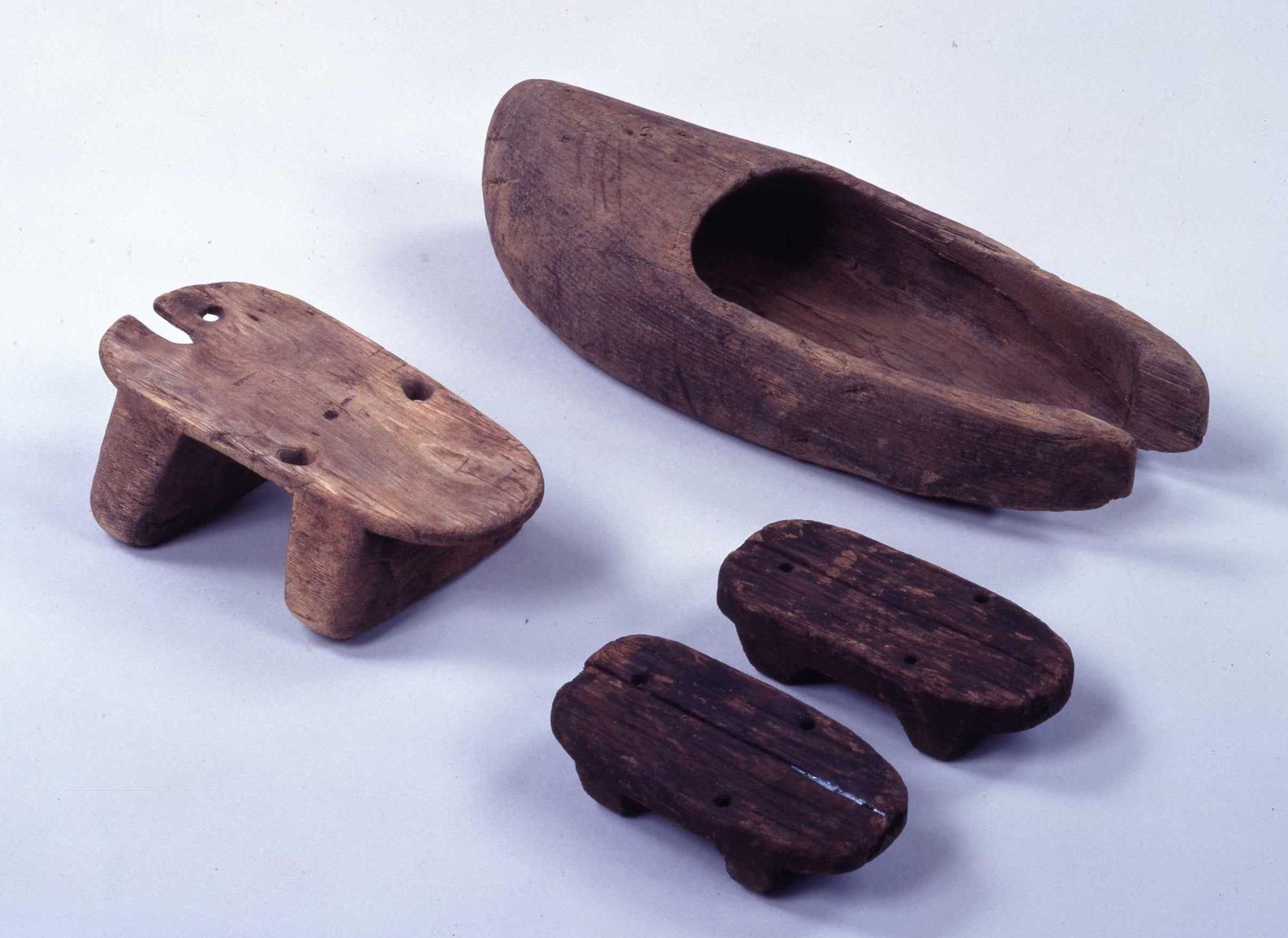 鴨遺跡から出土した靴や下駄の形をしている木製品の写真