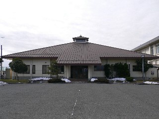茶色の屋根で白い外壁の新旭武道館の外観写真